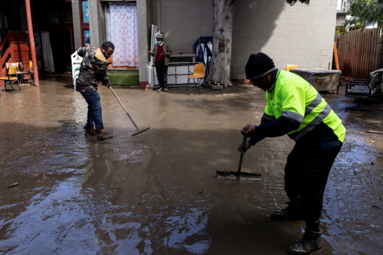 Local residents clean up the front yard of an Ethiopian Orthodox Church that was affected by floodwaters near the Maribyrnong River in Melbourne, Australia, October 14, 2022. 