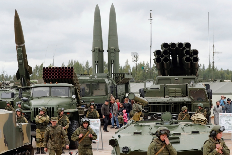 Visitors look at Russian tactical ballistic missiles and multiple rocket launcher during a military exhibition