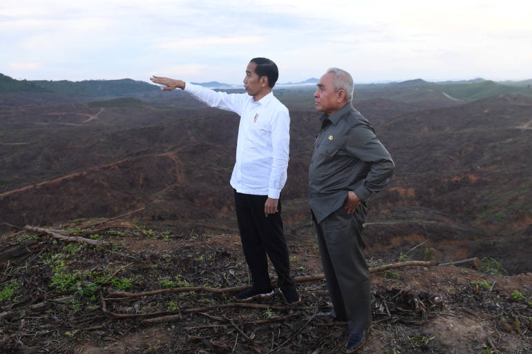 Indonesian President Joko Widodo gestures as the governor of East Kalimantan stands during their visit to an area, planned to be the location of Indonesia's new capital in East Kalimantan province, Indonesia.
