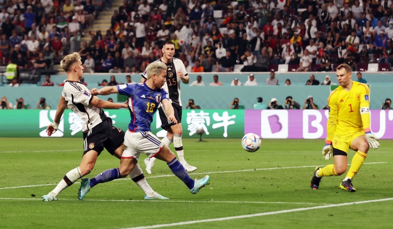 Asano kicking the ball, as goalkeeper bends to block it