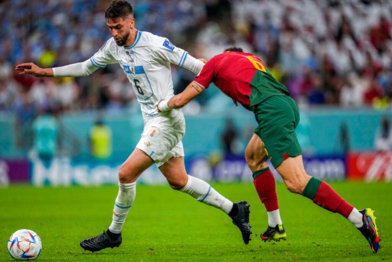 Uruguay's Rodrigo Bentancur fights for the ball with Portugal's Joao Palhinha during their World Cup group H football match.