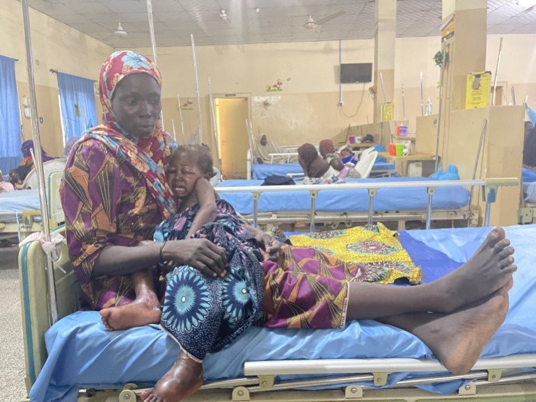 Yagana Modu consoles her daughter, Kaka, as she whimpers at the emergency ward in a stabilization center in Maiduguri