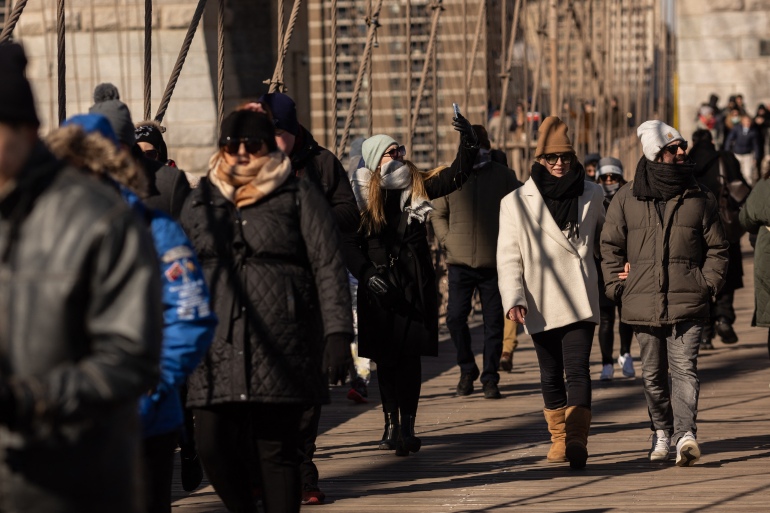 People walk over the Brooklyn Bridge